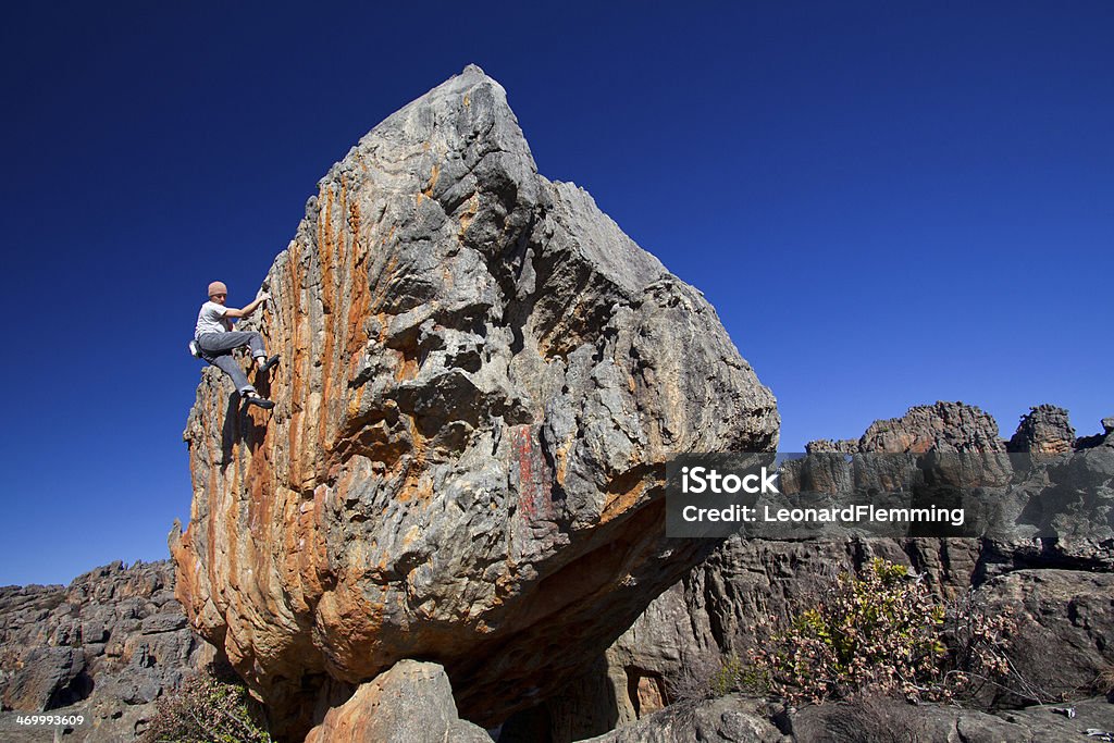 Solo climber A rock climber climbing on a high boulder in Rocklands, Cederberg Mountains, South Africa Boulder - Rock Stock Photo