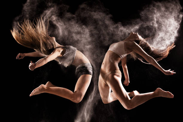 duas mulheres a saltar em uma nuvem de pó - modern dancing imagens e fotografias de stock