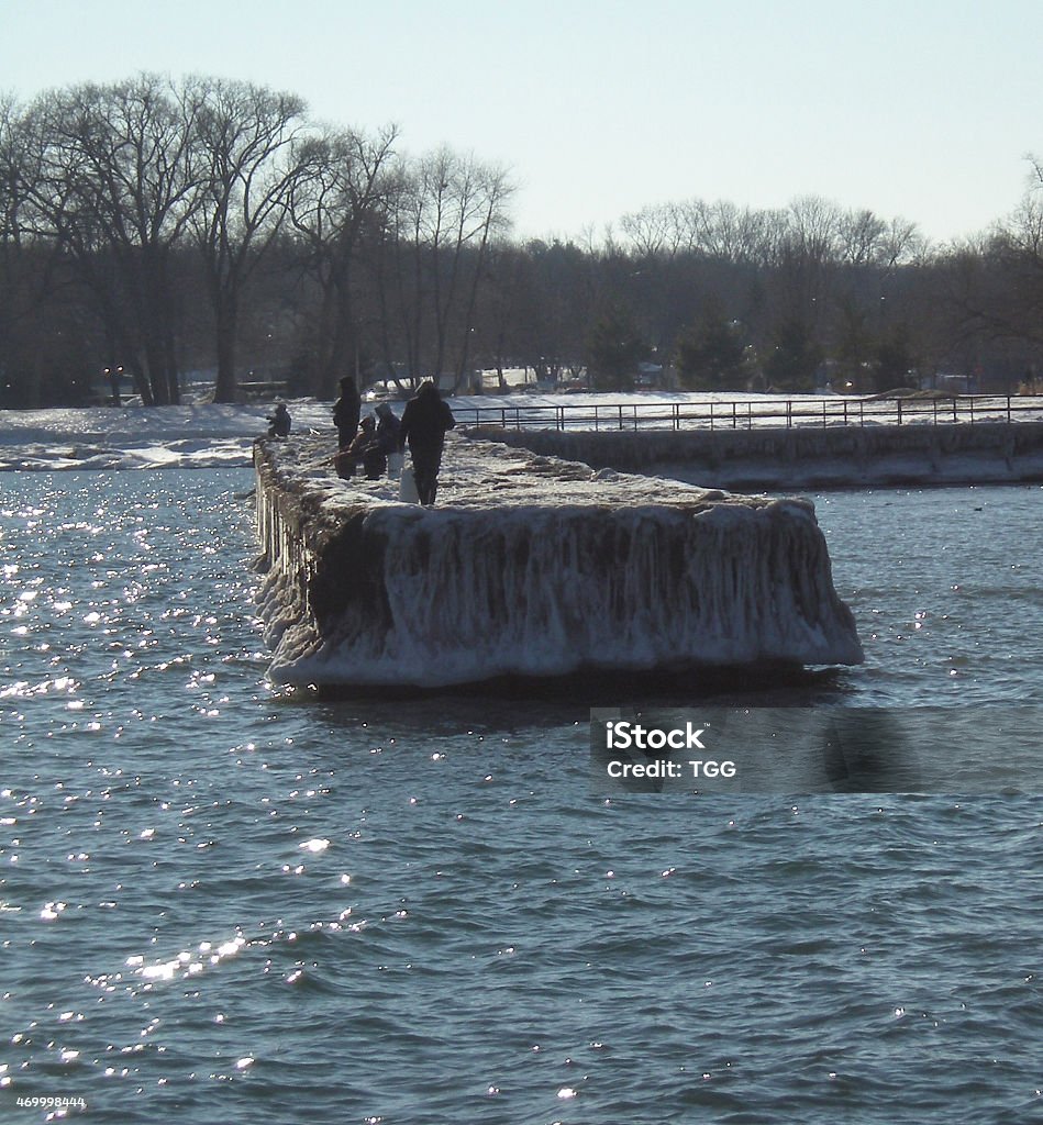 People Fishing Off Frozen Pier Photo was taken at the Bronte Harbour, Lake Ontario, in Oakville, Ontario, Canada during the winter of 2015 with a Canon camera. The photographer spent weeks in up to 40 below weather to capture these beautiful winter photographs.  Oakville - Ontario Stock Photo