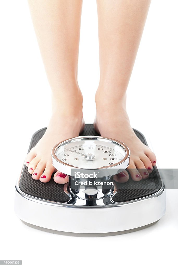 Young woman standing on a scale Diet and weight, young woman standing on a scale, only feet to be seen Body Mass Index Stock Photo