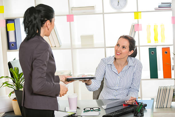 istock Two women chat to each other in the office. 470001744