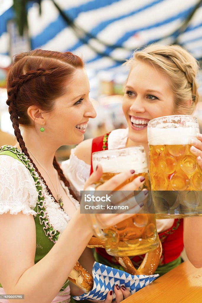 Women with traditional Bavarian dirndl in beer tent Young women in traditional Bavarian clothes - dirndl or tracht - on a festival or Beer Fest in a beer tent Traveling Carnival Stock Photo