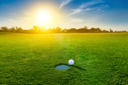 A golf ball close to the hole at sunset.  http://blog.michaelsvoboda.com/GolfBanner.jpg