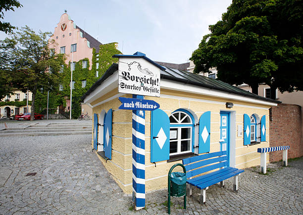 Dachau, Germany - July 6, 2013: Small toll house at Karlsberg in the old town of Dachau. In former times and up to the year 1926 marketeers and tradesmen had to pay toll to enter the market town of Dachau. On the background is the old town house of Dachau