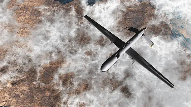 Photo of Predator Drone from above, flying over clouds and dessert