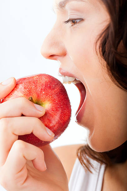 istock Young woman bites in a apple 470007995