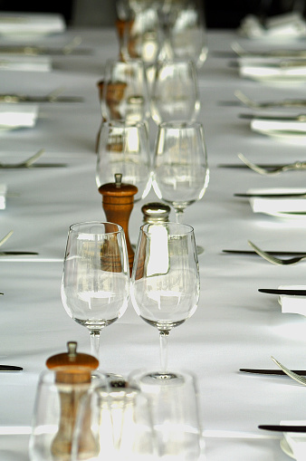 A perspective view down the length of a restaurant table which is set up ready for customers.