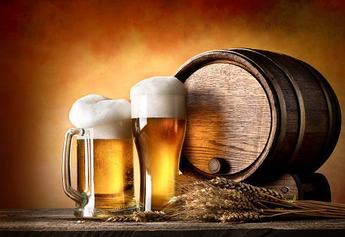 Beer with wheat and barrel on a wooden table