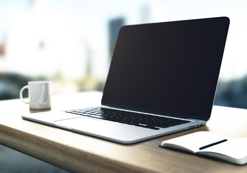 laptop with cup and diary on yellow table