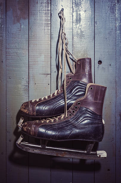 A vintage pair of men's ice skates hang from the cold room door in the basement of an old home.  Mild cross processing applied.
