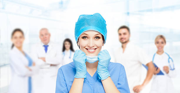 médico cirúrgico mulher feliz sorrindo com a equipe de grupo - image created 21st century blue colors old - fotografias e filmes do acervo