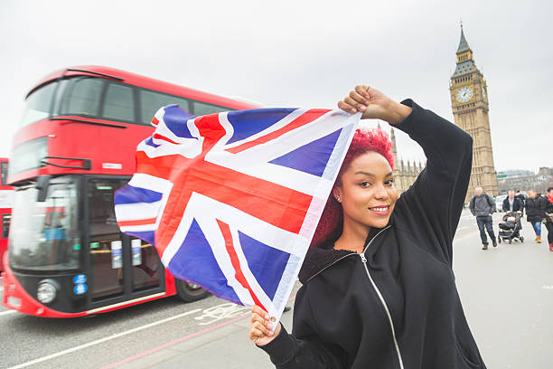wanita cantik redhair memegang bendera britania raya di london - orang memakai bendera inggris potret stok, foto, & gambar bebas royalti