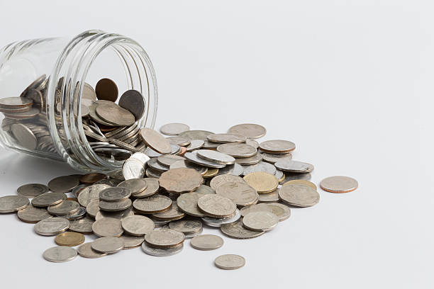 istock Jar spilling coins of multiple currencies 470024370