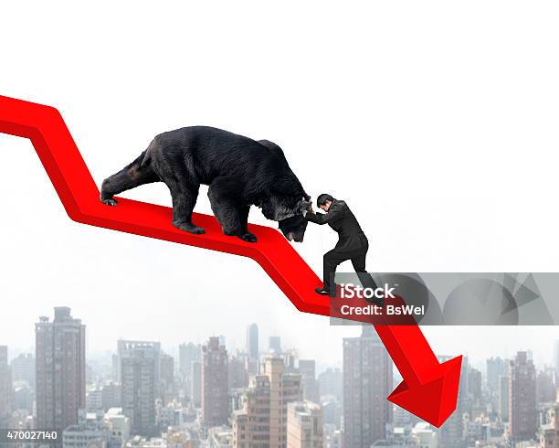 Businessman Against Bear On Arrow Downward Trend Line With Citys Stock Photo - Download Image Now