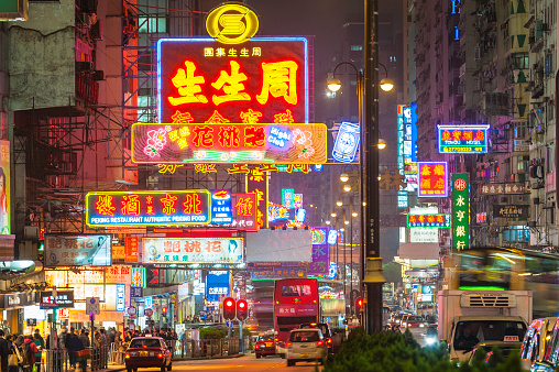 Vibrant neon signs and bright street lights glowing above the busy night traffic of taxis, double decker buses and pedestrians along Nathan Road in the crowded Tsim Sha Tsui district of Kowloon, Hong Kong, China. ProPhoto RGB profile for maximum color fidelity and gamut.