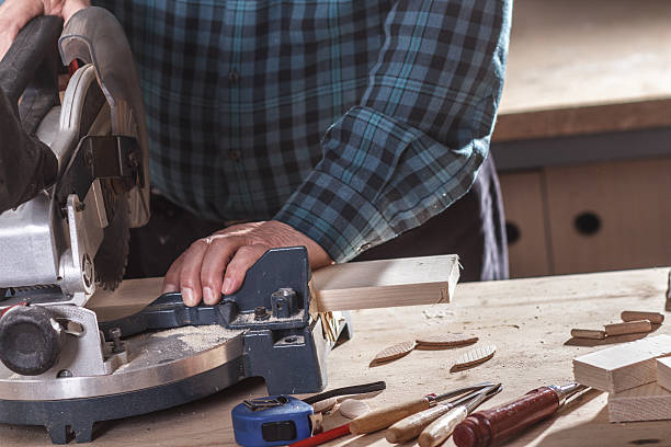 istock Carpenter cutting wooden plank with circular saw. 470032886