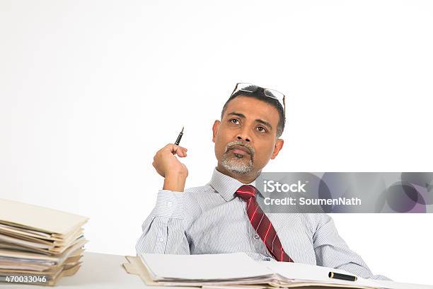 Mature Businessman Lost In Deep Thoughts At His Desk Stock Photo - Download Image Now