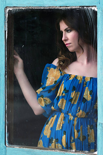 istock Beautiful girl looking out the window 470038212