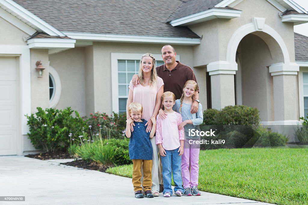 Famiglia in piedi nel cortile anteriore della casa - Foto stock royalty-free di Famiglia