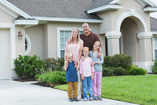 istock Family standing in front yard of home 470040410