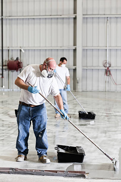 istock Professional Painters Put Down a Coating in Airport Hanger 470040562