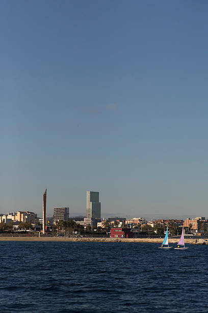 Barcelona - veil boats sailing in front of Barceloneta beach stock photo