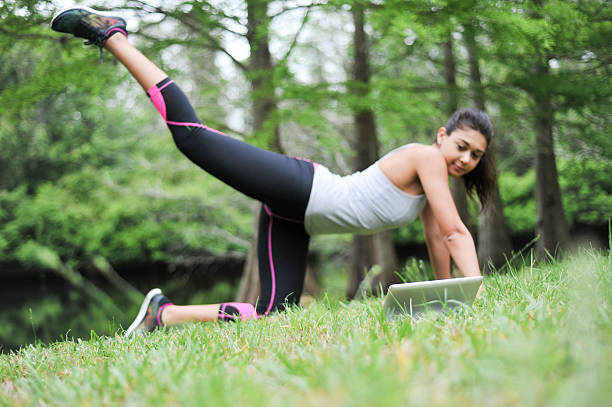 Young Woman Exercising While Watching Video Tutorials stock photo