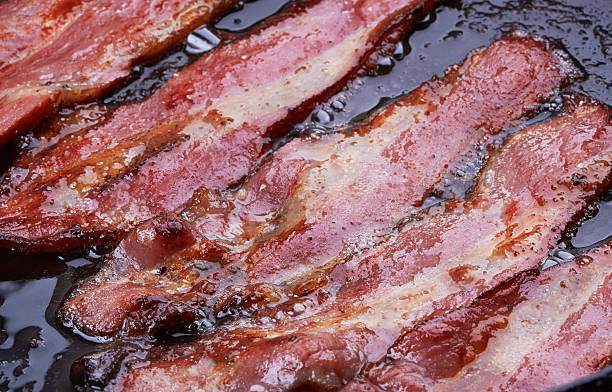 istock Five strips of bacon frying in oil 470040876