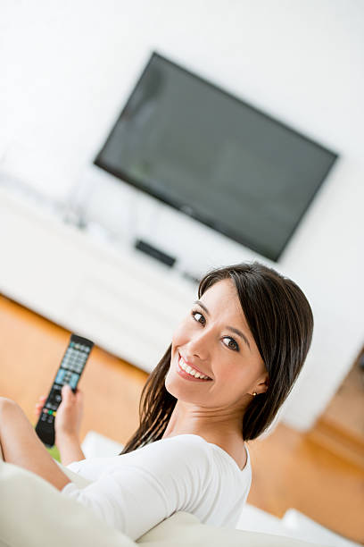 istock Happy woman watching tv at home 470041802