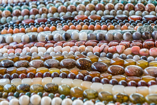 Assorted strings of gem stones beds over