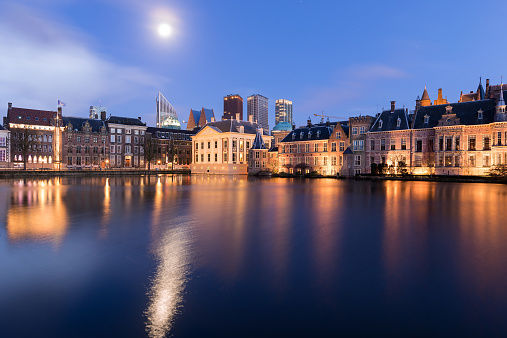 The Hague (Den Haag) skyline with Mauritshuis Museum, Binnenhof palace (Dutch Parliament), and modern skyscrapers reflected in the Hofvijver canal, The Netherlands.