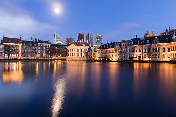 The Hague Under The Moon The Hague (Den Haag) skyline with Mauritshuis Museum, Binnenhof palace (Dutch Parliament), and modern skyscrapers reflected in the Hofvijver canal, The Netherlands. binnenhof photos stock pictures, royalty-free photos & images