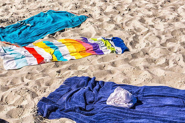 istock Colorful Bath Towels On Sandy Footprint Vacation Beach 470044294