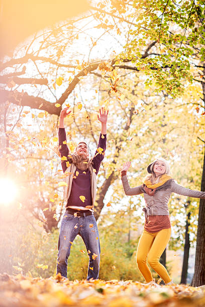 istock Couple throwing leaves in park and having fun during autumn. 470047154