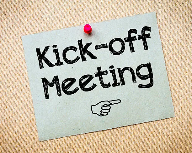 Kick-off meeting Message. Recycled paper note pinned on cork board. Concept Image