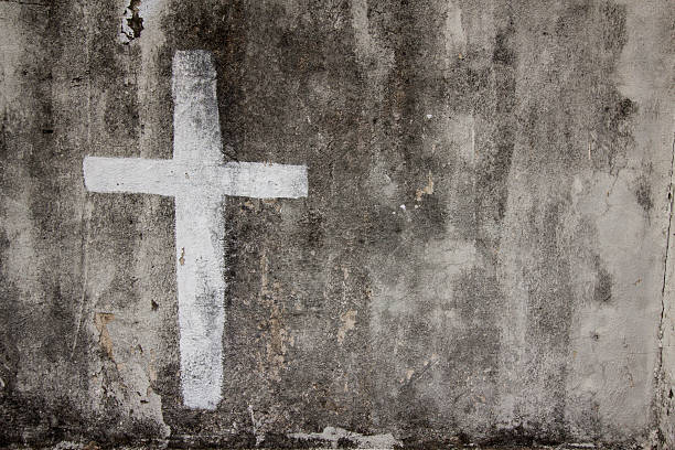 White cross on cemetery wall stock photo