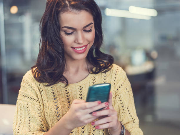 istock Young smiling woman text messaging on mobile phone. 470054234