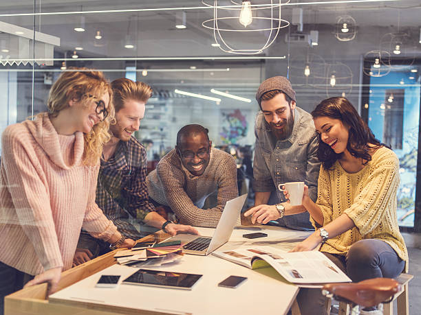 istock Cheerful start up team using laptop in the office. 470054248