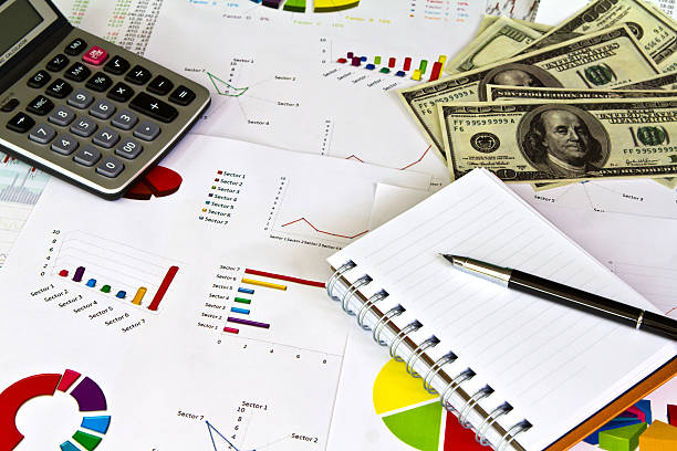 istock Pen ,calculator and dollars on financial Graphs 470054297