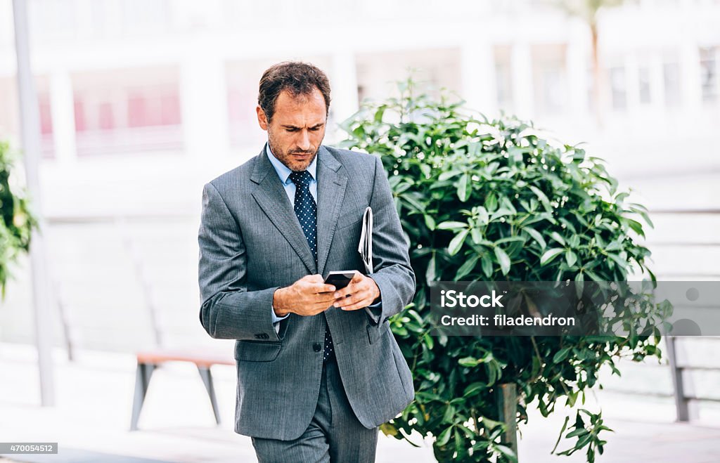 Businessman in Dubai A businessman texting and walking in Dubai. 2015 Stock Photo