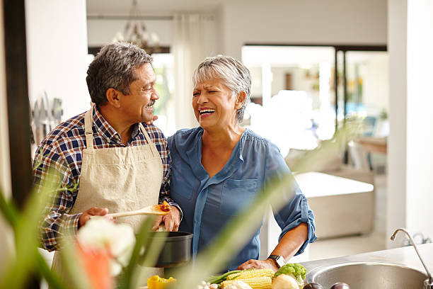 putting viel liebe in ihre mahlzeit - senior couple couple partnership discussion stock-fotos und bilder