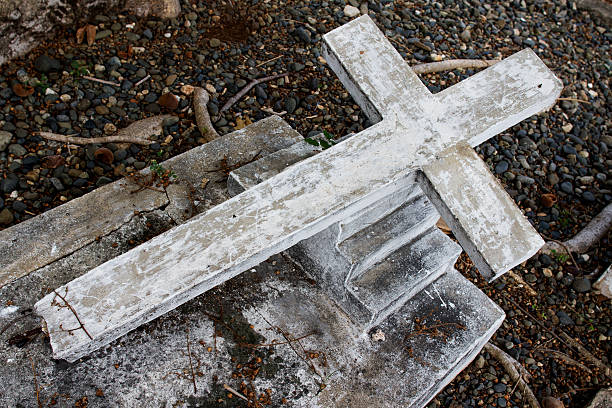 Cross lying on the floor on a cemetery abandoned stock photo