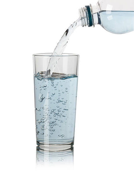 istock Pouring water into glass on white background 470058273