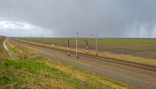 Railroad through natureunder a rain shower in spring