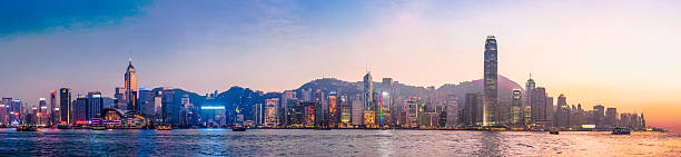 香港ハーバーに沈む夕日の象徴的な高層ビル、ネオン照明パノラマ中国 - hong kong skyline panoramic china ストックフォトと画像