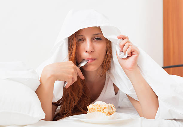 istock woman eating sweet cake under sheet 470063637