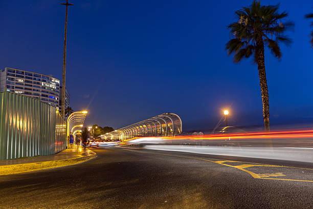 Lima, Peru - January 13, 2015: Night time traffic on Lima roads. Cars, taxis and joggers make their way across a bridge at Miraflores