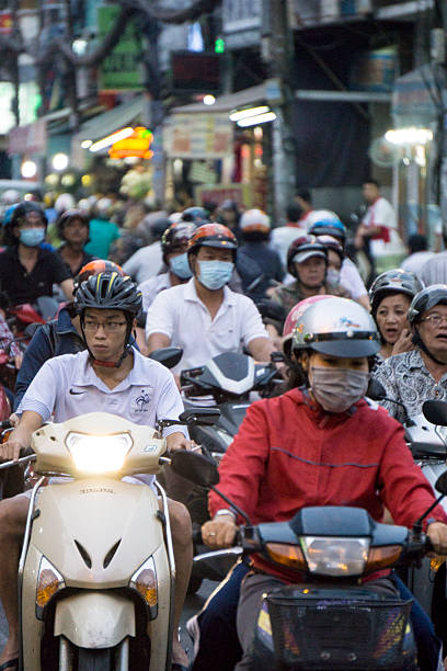 Ho Chi Minh, Vietnam - January 2, 2015: Lots of people on mopeds and scooters in Ho Chi Minh city. Bicycles and motorbikes are the most popular form of transport throughout Vietnam. Traffic and congestion is a major problem.