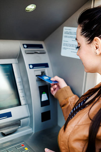 istock Young woman using a cash machine 470085620
