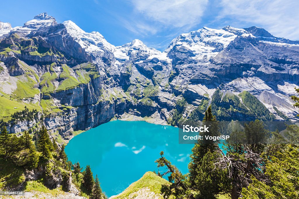 Panorama view of Oeschinensee (Oeschinen lake) on bernese oberla The panorama in summer view over the Oeschinensee (Oeschinen lake) and the alps on the other side near Kandersteg on bernese oberland in Switzerland. Lake Stock Photo